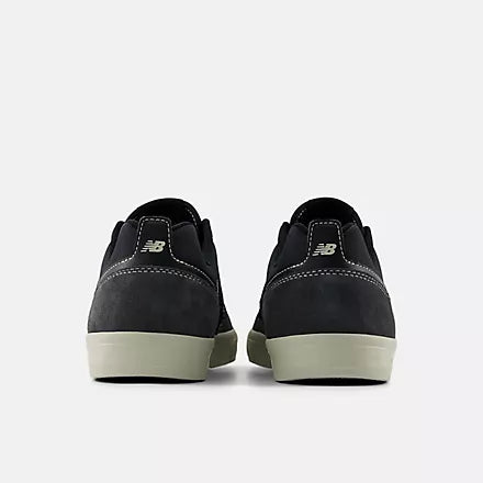 Black sneakers with white soles on a light gray background