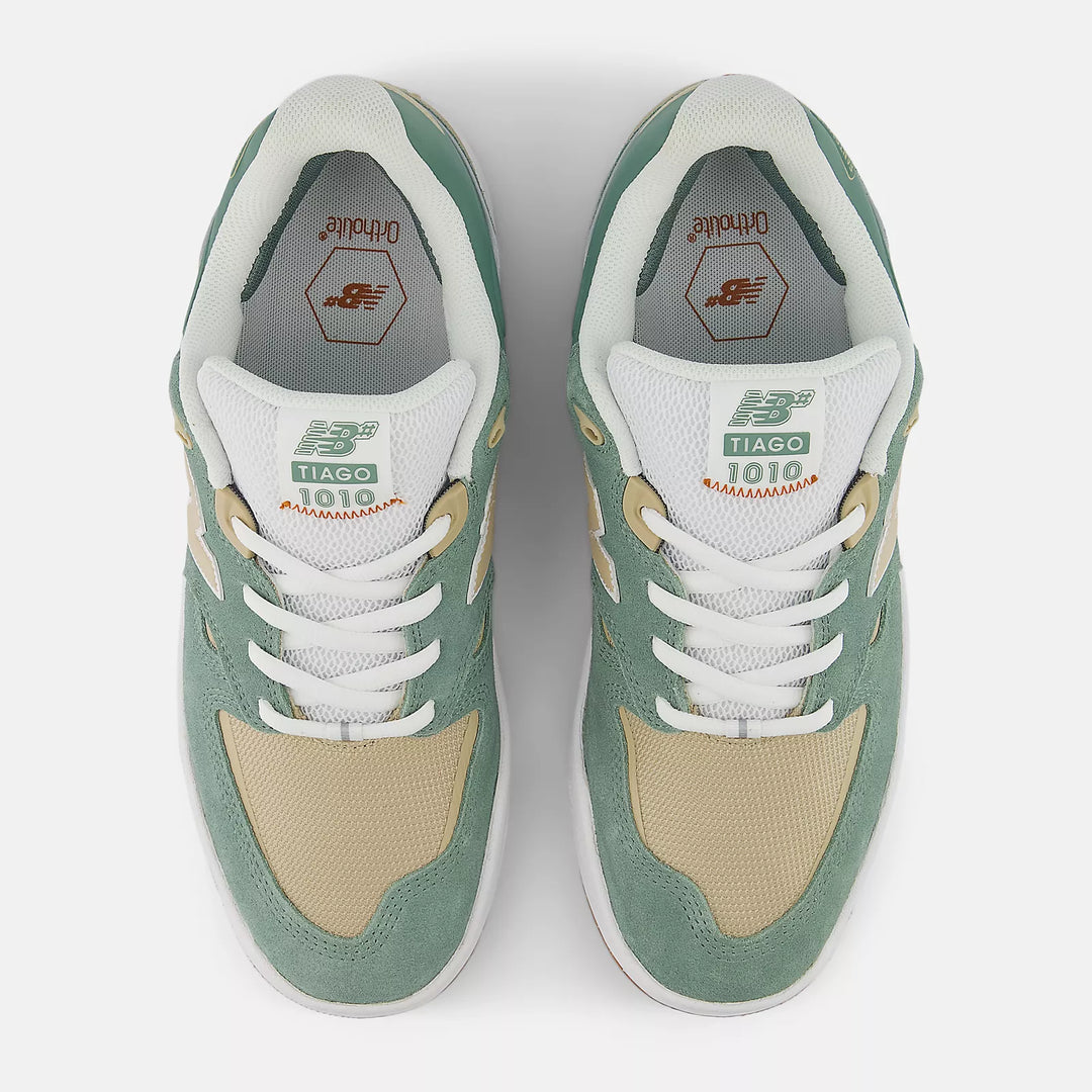 Pair of green and beige sneakers with white laces on a light gray background