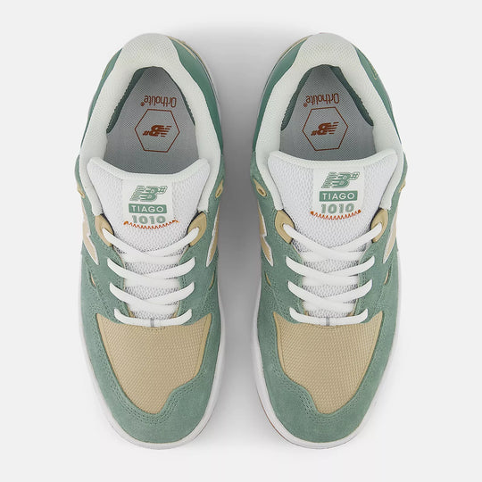Pair of green and beige sneakers with white laces on a light gray background
