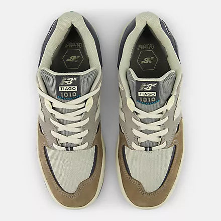 Pair of beige and black sneakers with New Balance branding on a white background
