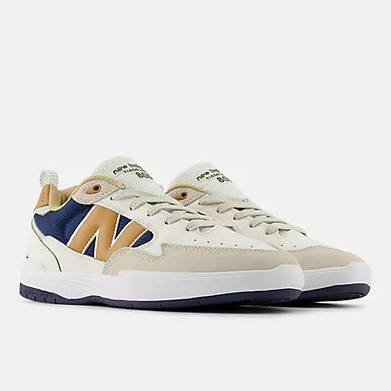 Beige sneaker with brown and blue accents on a white background