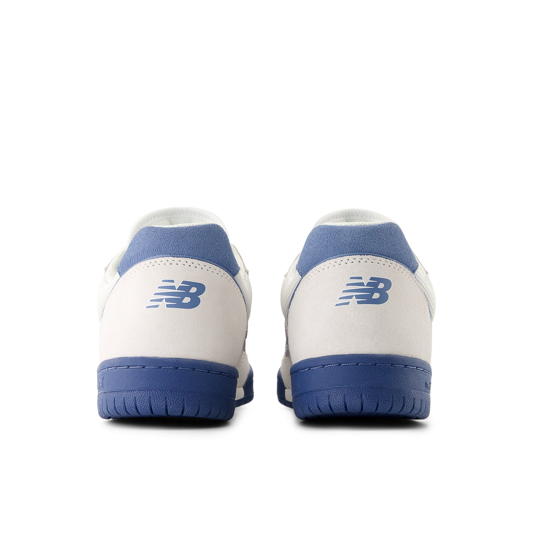 White sneakers with blue soles and New Balance logo on a white background