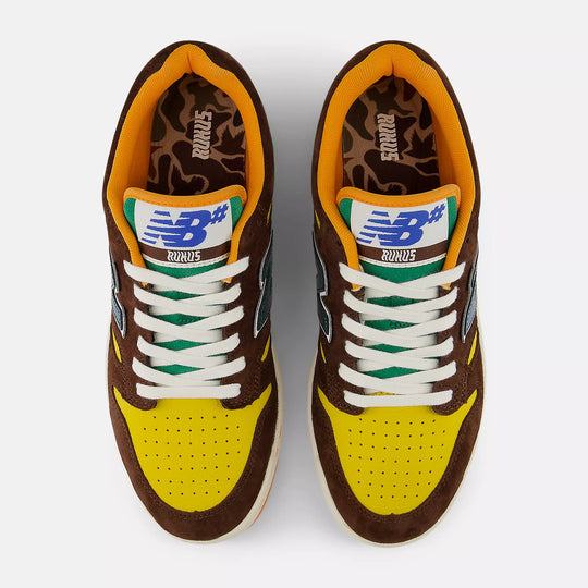 Pair of brown and yellow sneakers with white laces 