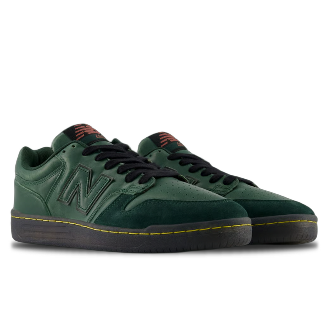 Green sneakers with black laces on a white background