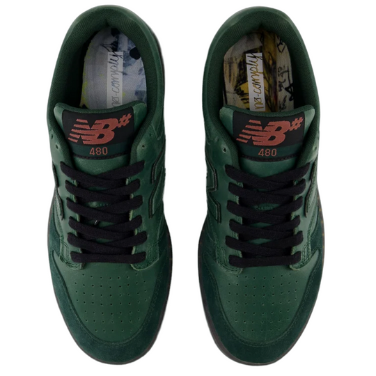 Green sneakers with black laces on a white background