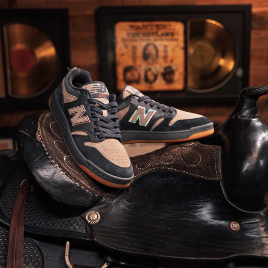 Pair of black and beige sneakers on a leather saddle with a vintage-style background.