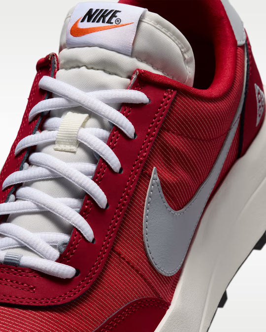 Red sneaker with white laces and Nike logo on a white background