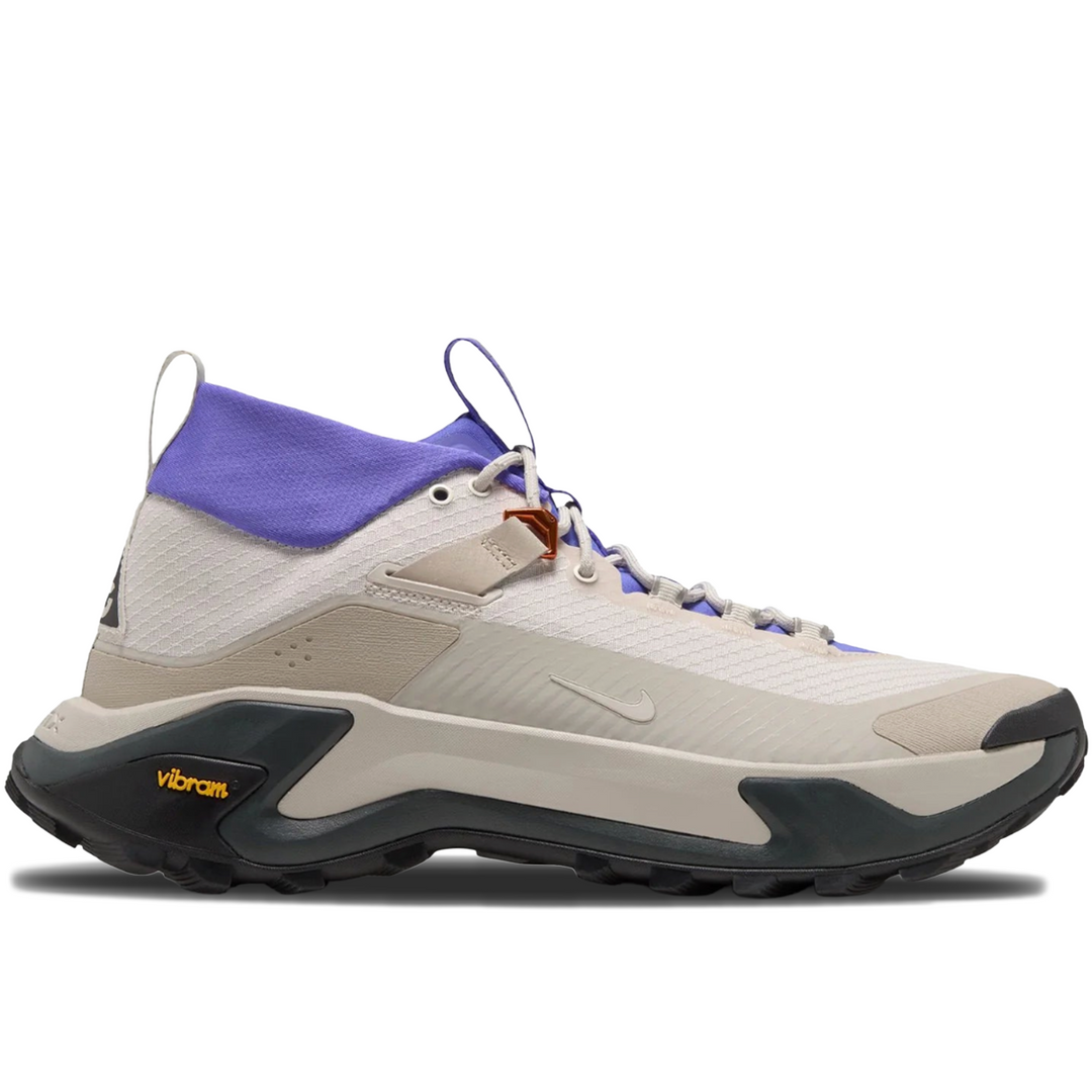 A Nike mid-top athletic shoe in off-white and beige with a purple collar, dark gray outsole, and a small orange accent near the lace area, shown on a white background.