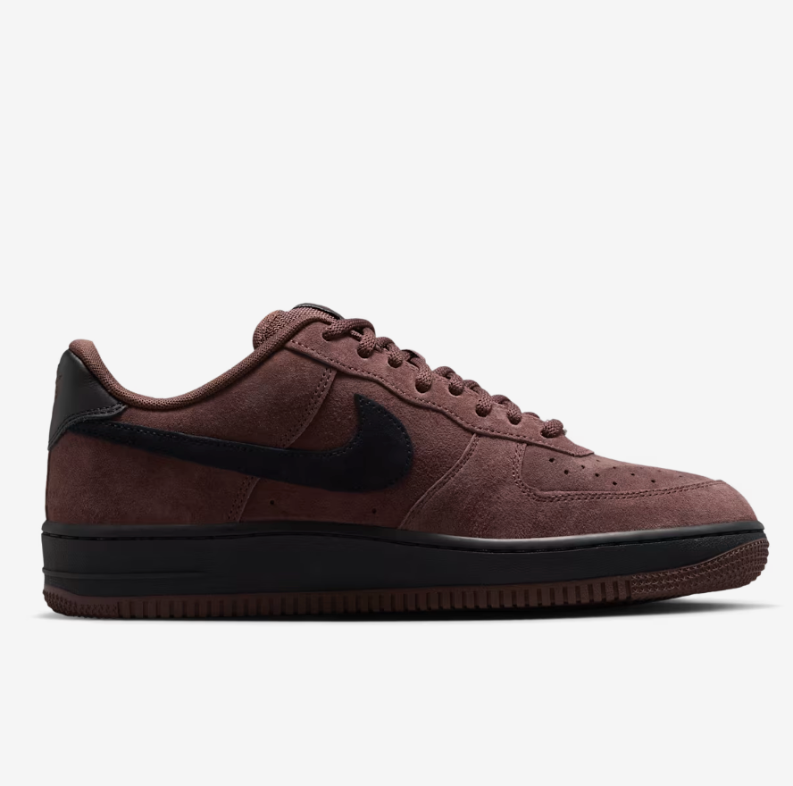 A Nike Air Force 1 sneaker in a dark brown suede and black leather finish, shown from a side profile view against a light gray background.