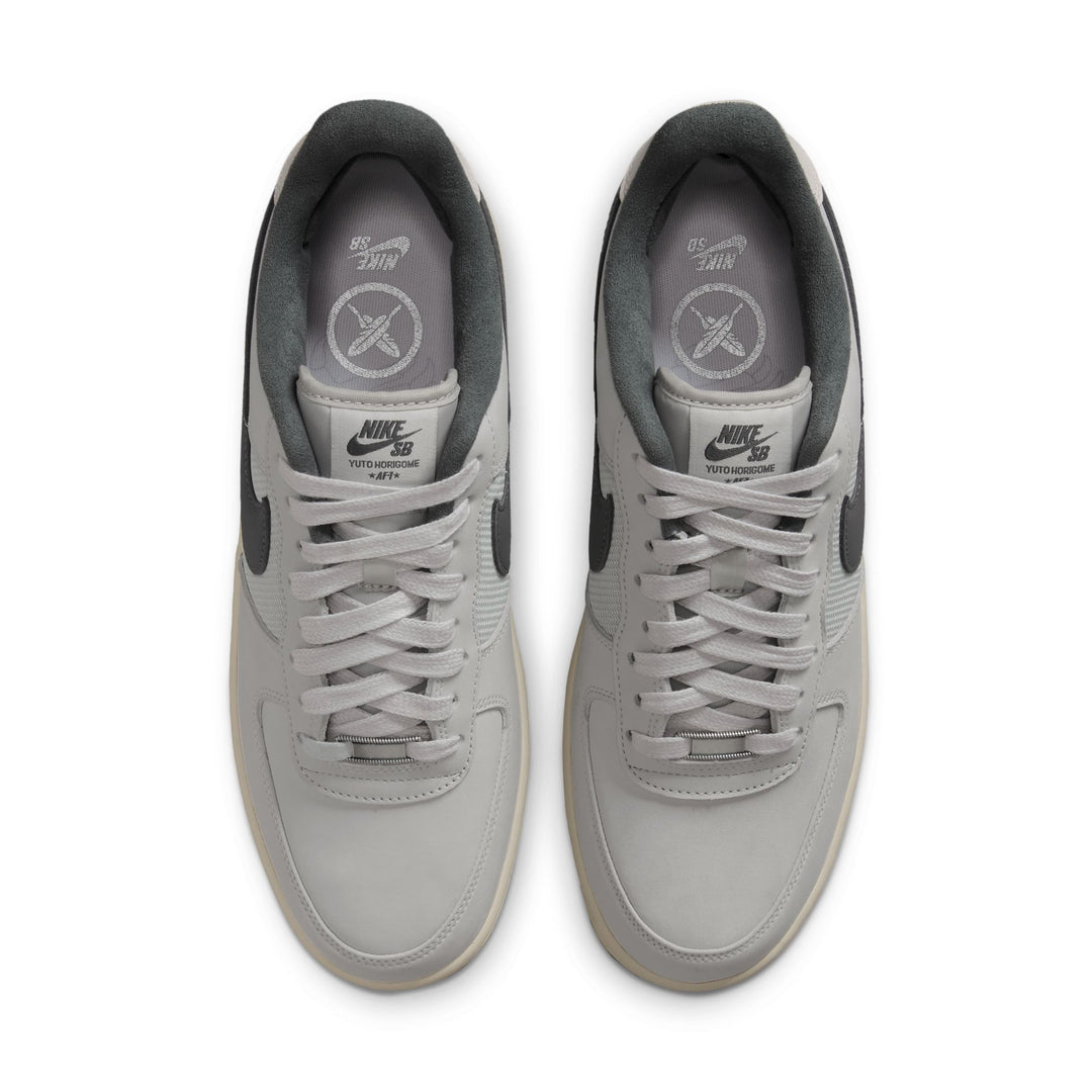 A pair of Nike Air Force 1 Low sneakers in light gray and dark gray, shown from a top-down view on a white background.