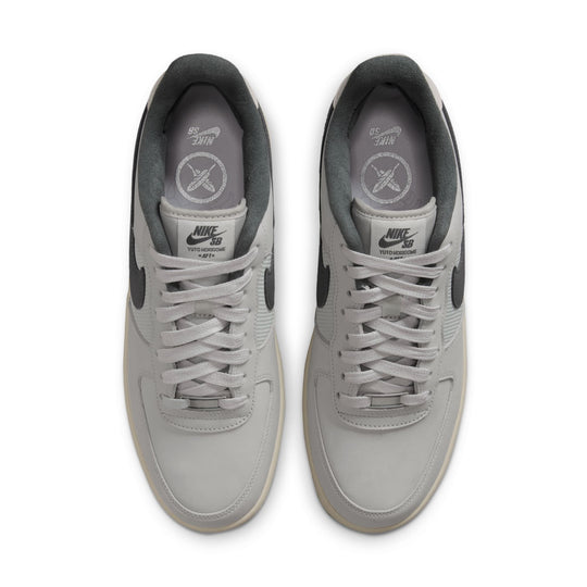 A pair of Nike Air Force 1 Low sneakers in light gray and dark gray, shown from a top-down view on a white background.