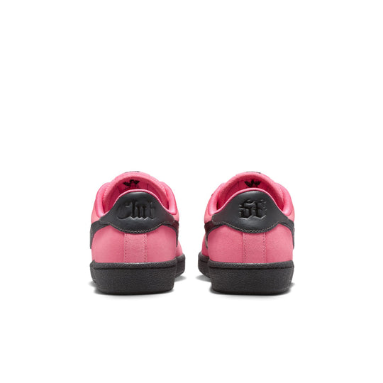 Pink sneakers with black soles on a white background
