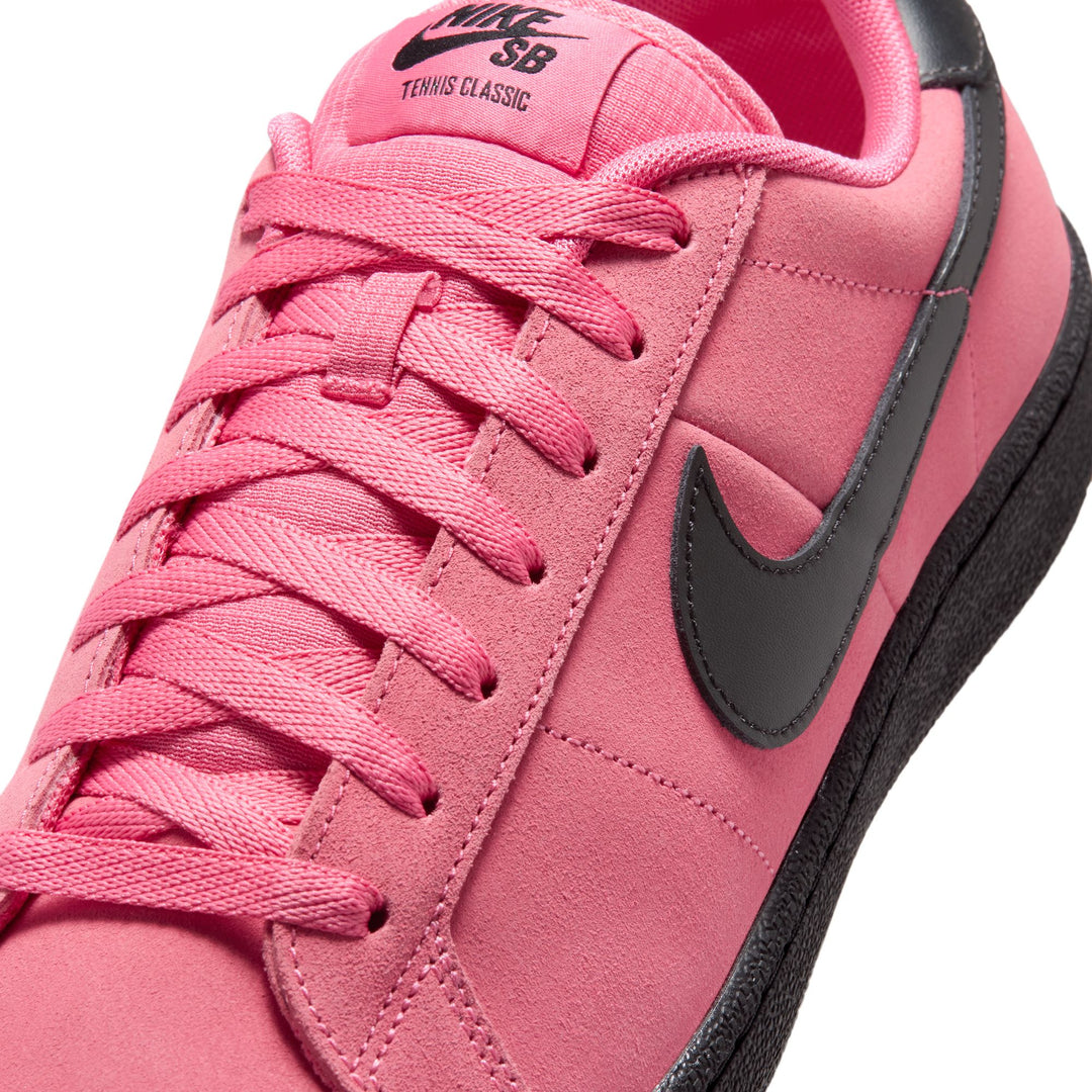 Pink sneaker with black swoosh logo on a white background