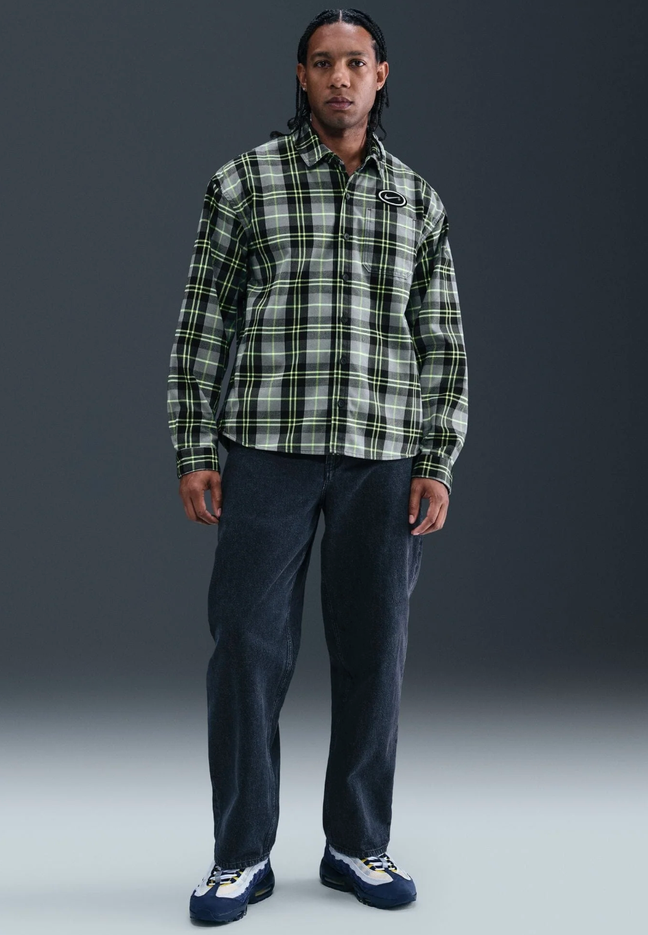 Person wearing a nike koston plaid shirt and dark pants 