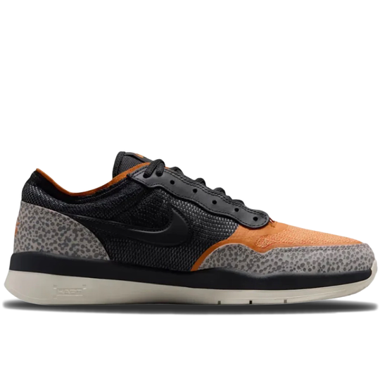 A Nike low-top sneaker featuring a black mesh upper, gray and black leopard print overlays, and vibrant orange suede panels on the toe and eyestay area, set against a plain white background.