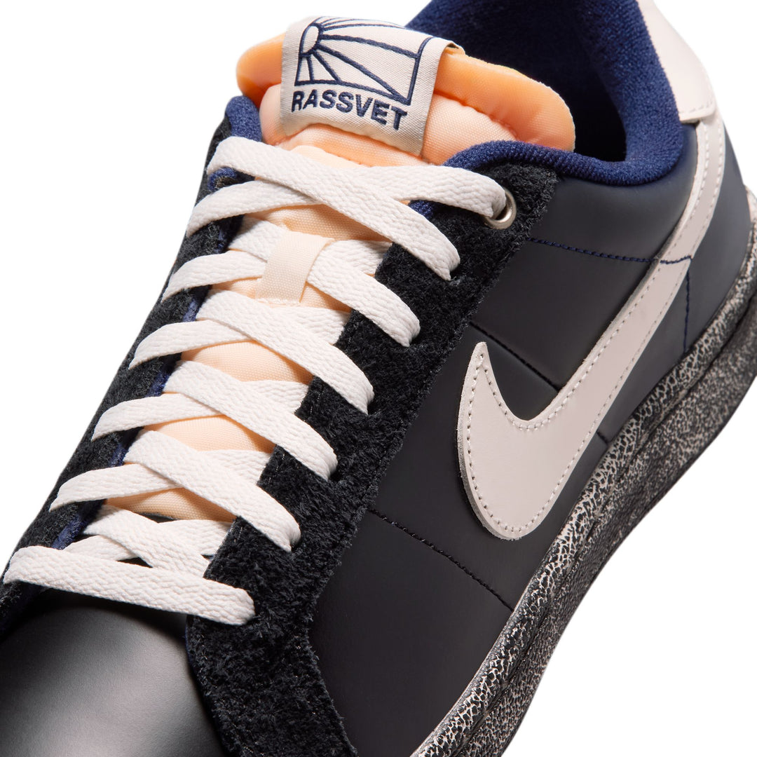 Black and gray sneaker with white laces and a visible brand logo on a white background