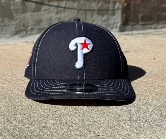 navy baseball cap with a red star logo on a concrete surface