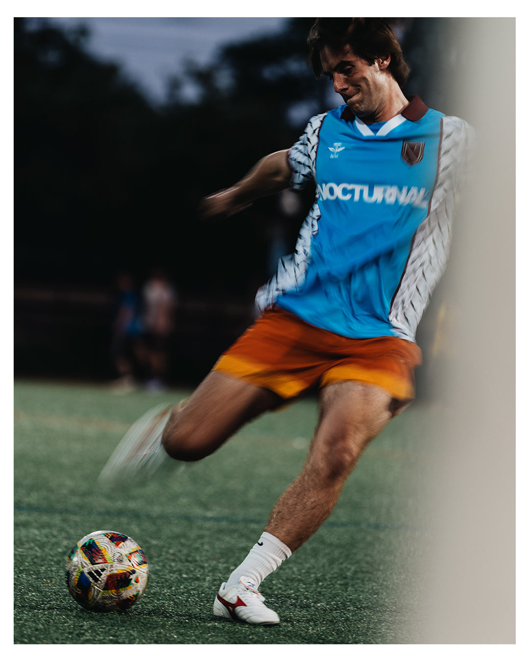 Person playing soccer on a field wearing the nocturnal soccer jersey