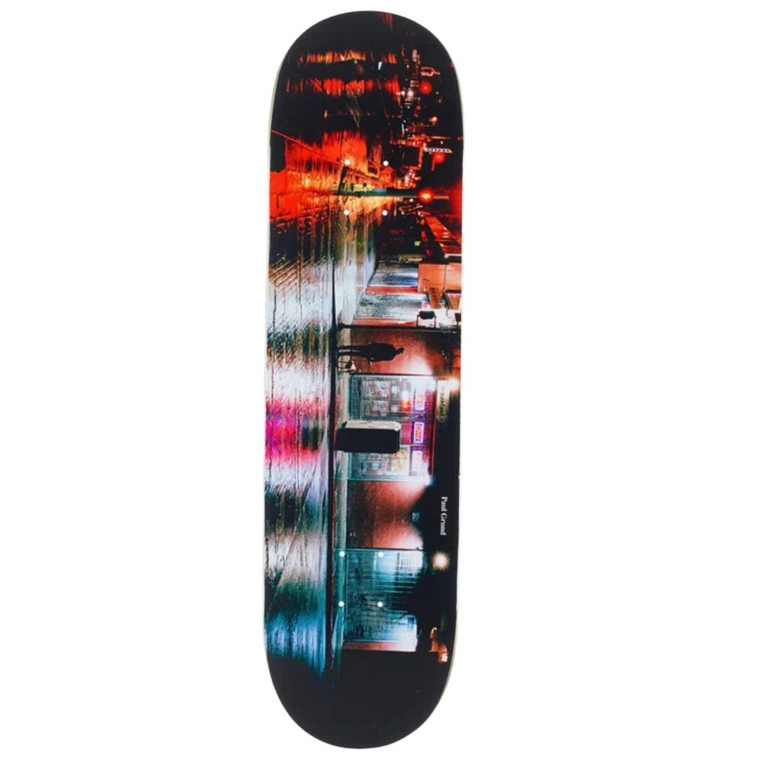 Skateboard deck with a colorful cityscape design on a white background
