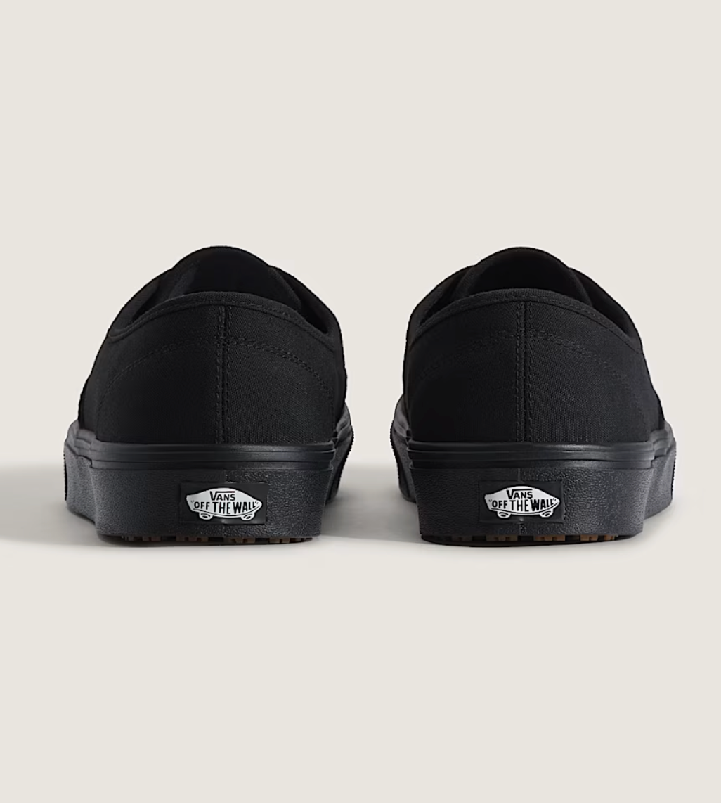 Black slip-on shoes with 'Off the Wall' logo on a light gray background