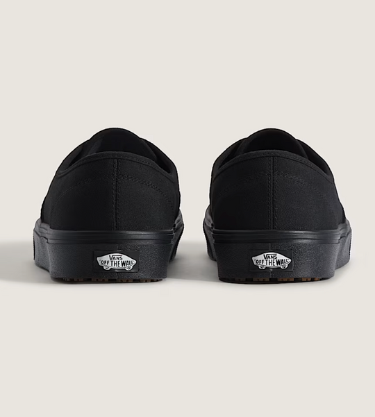 Black slip-on shoes with 'Off the Wall' logo on a light gray background
