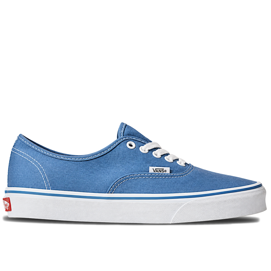 A single Vans classic low-top sneaker in a medium blue canvas finish, featuring white laces, a white rubber sole, and a thin blue stripe along the midsole, set against a plain white background.
