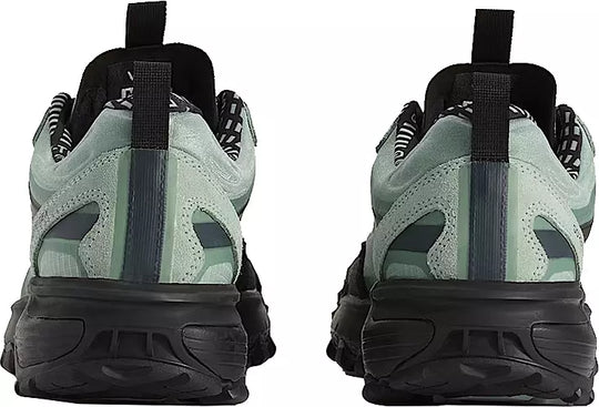 Pair of green and black sneakers shown from the back on a white background