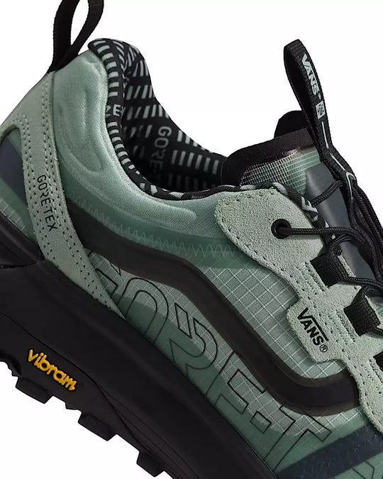 Green hiking shoe with black accents and visible branding on a white background