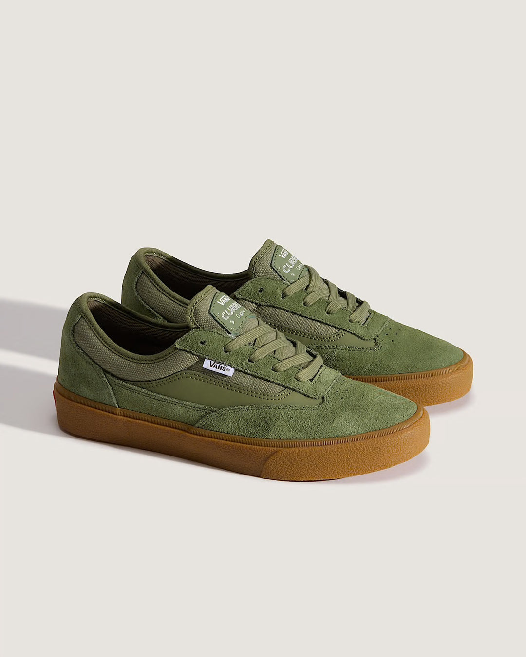 Green sneakers with brown soles on a light gray background