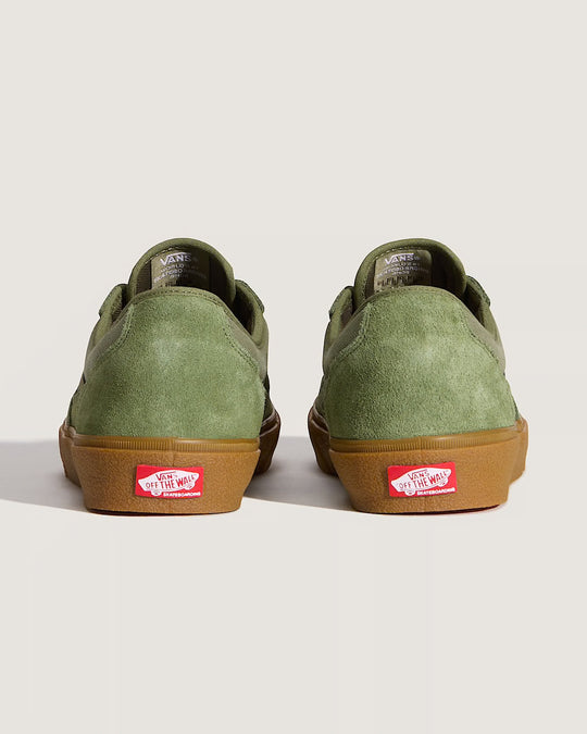 Green sneakers with brown soles on a light gray background