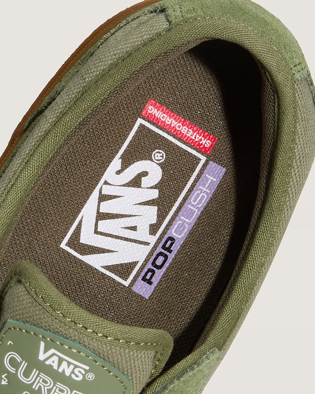 Close-up of a green Vans sneaker with a focus on the sole and brand logo.
