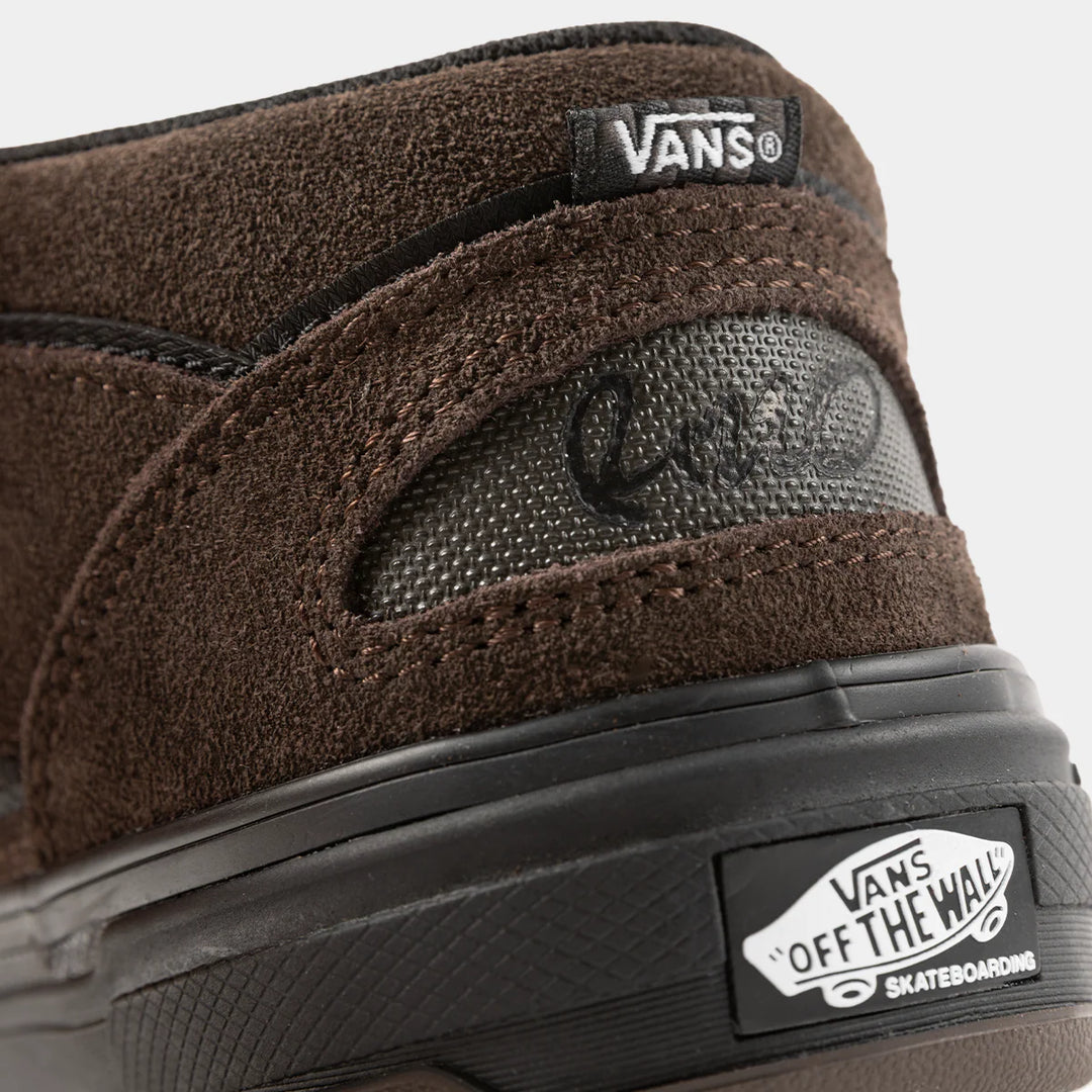 Close-up of a brown Vans sneaker with visible branding on a white background