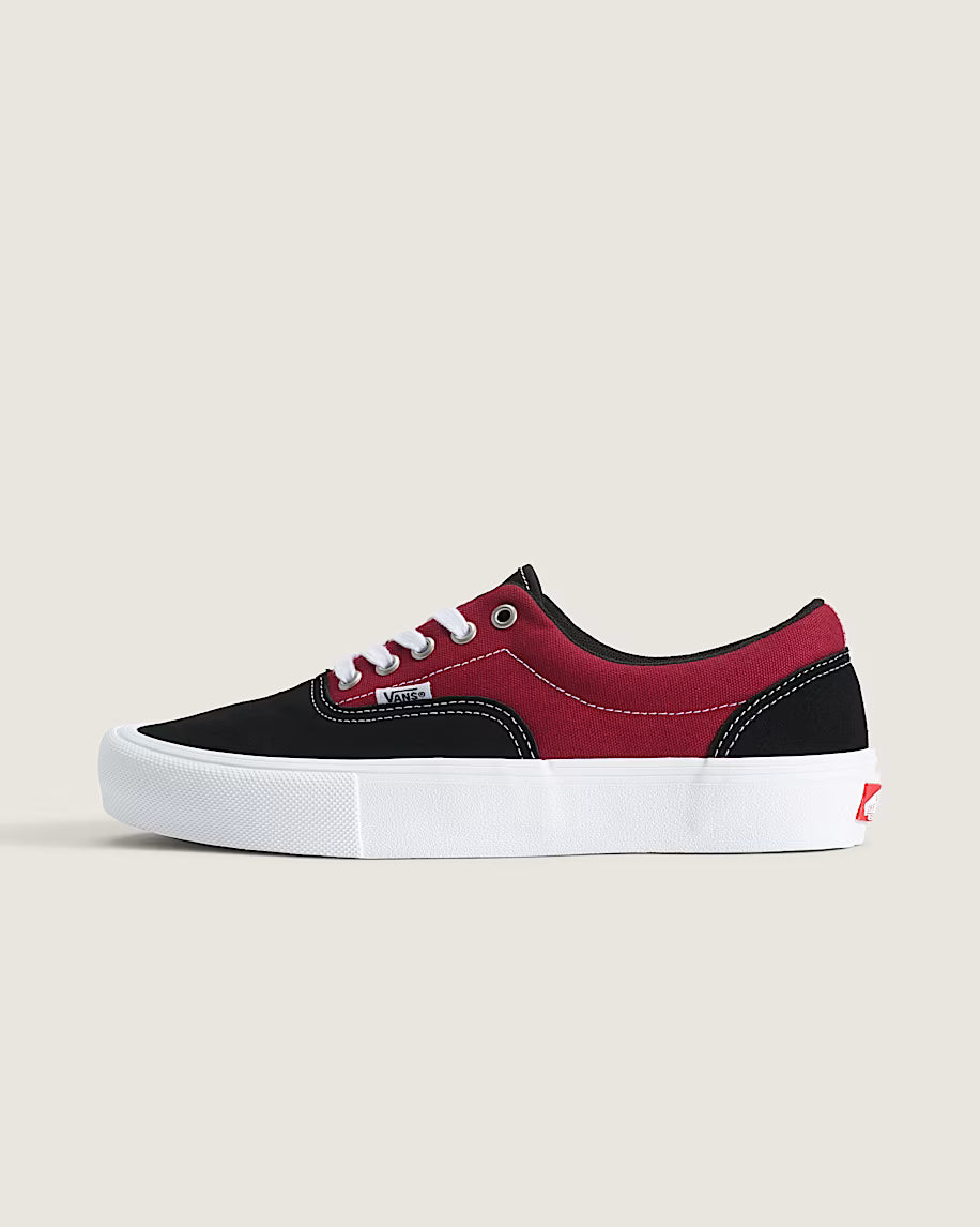 Red and black sneaker with white sole on a beige background