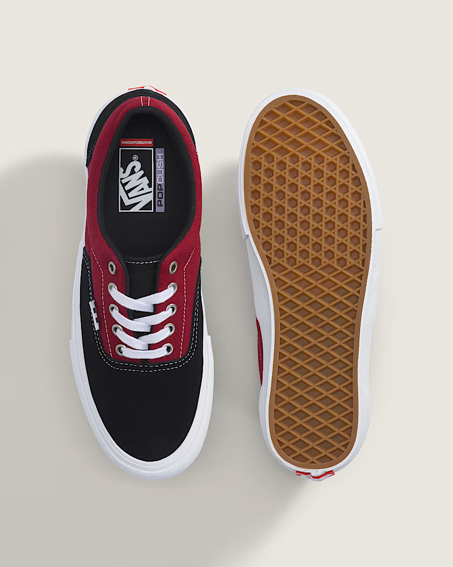 Black and red sneaker with white laces on a light gray background