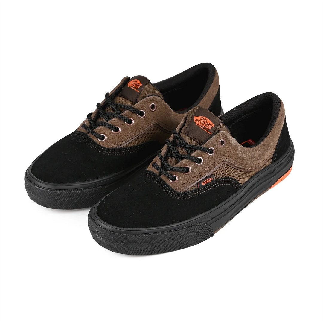 Pair of black and brown sneakers with orange accents on a white background