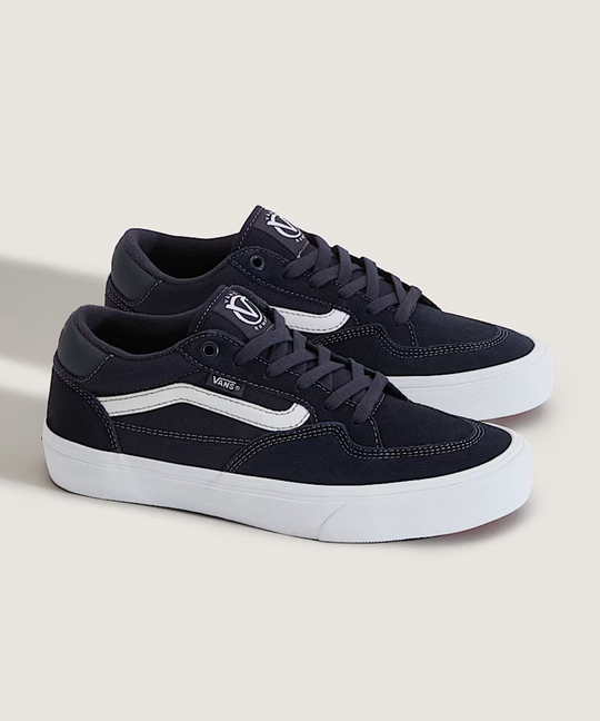 Navy blue sneakers with white soles on a light gray background