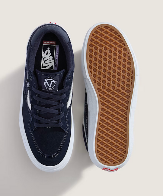Navy blue sneakers with white soles on a light beige background