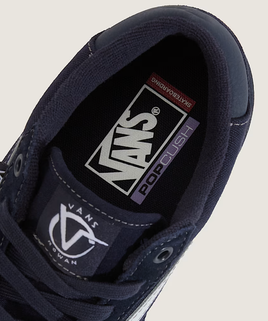 Navy blue Vans sneaker with pop cush 
brand logo on a light gray background