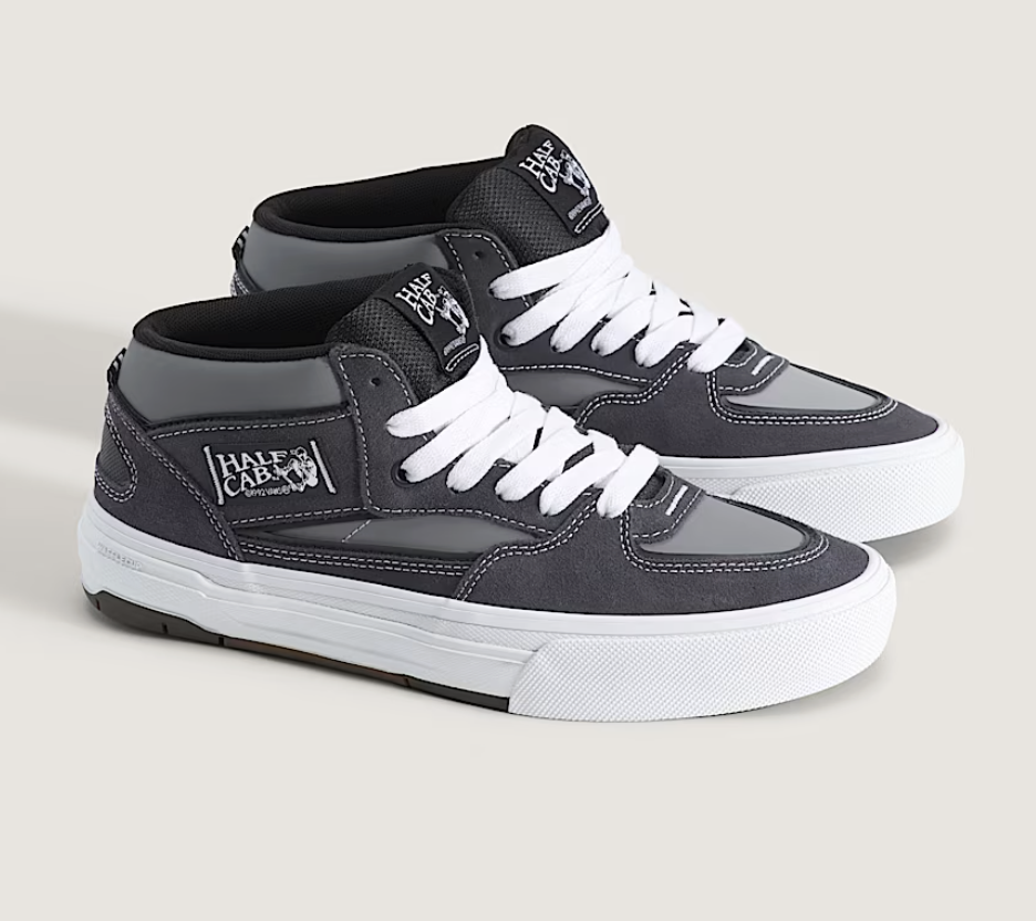 Gray and black sneakers with white laces on a light gray background