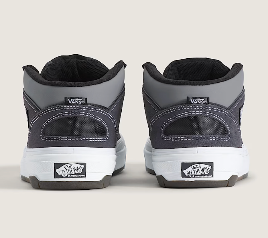 Gray and black Vans sneakers shown from the back on a light gray background