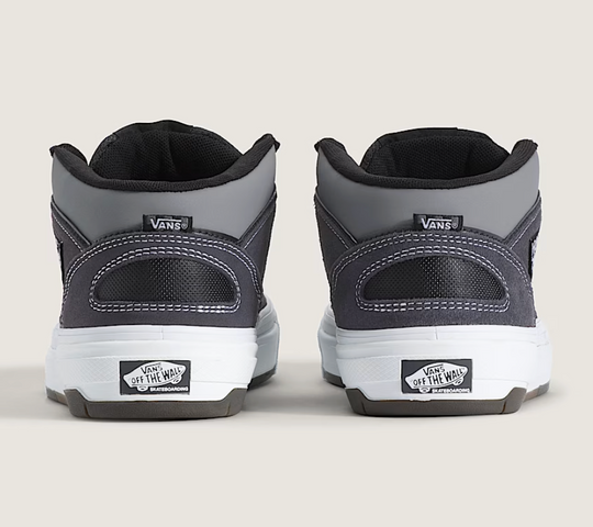 Gray and black Vans sneakers shown from the back on a light gray background