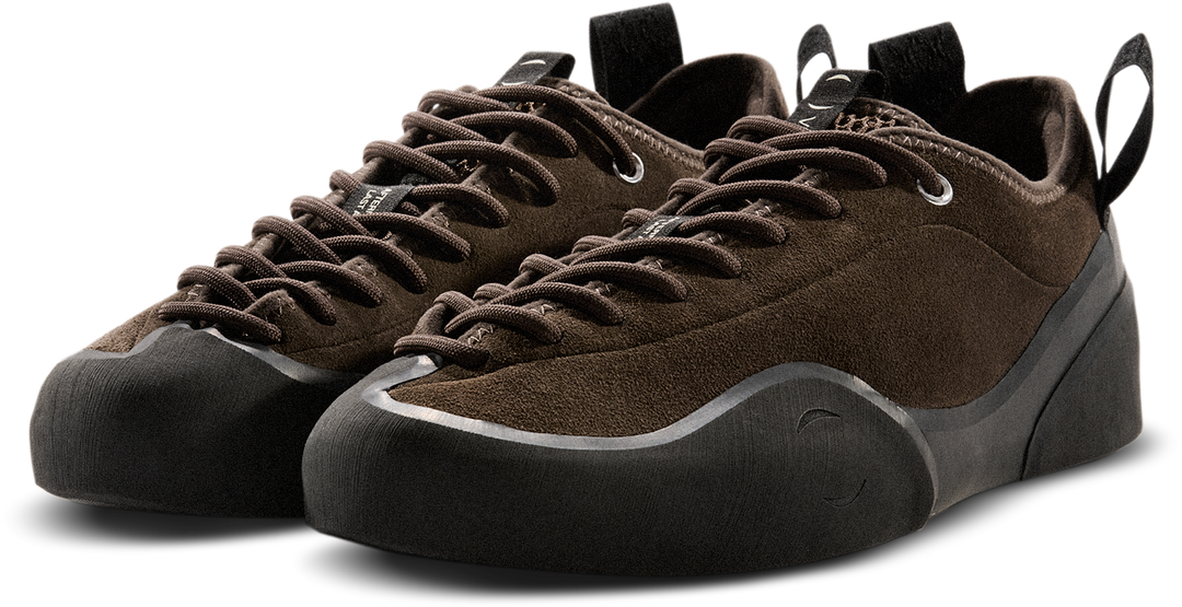 Pair of brown climbing shoes with black soles on a white background