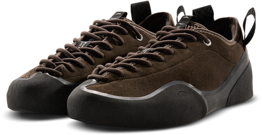 Pair of brown climbing shoes with black soles on a white background