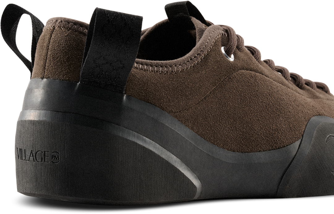 Brown sneaker with black sole on a white background