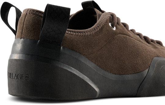 Brown sneaker with black sole on a white background