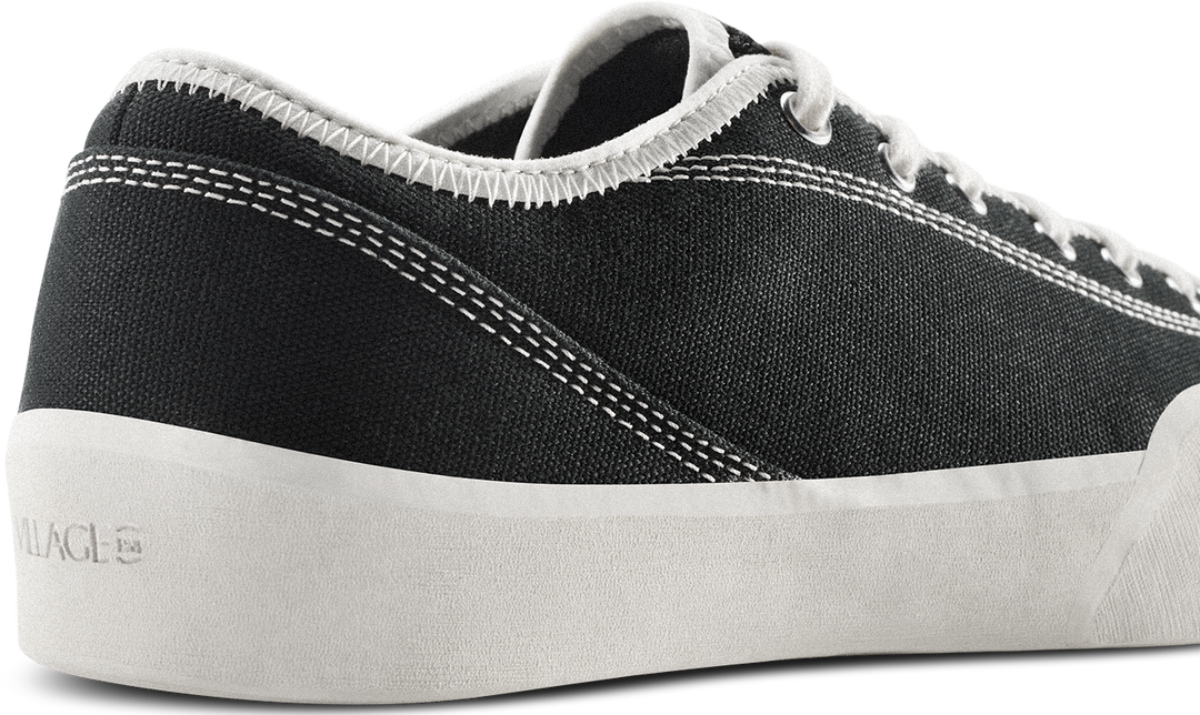 Black sneaker with white sole on a white background