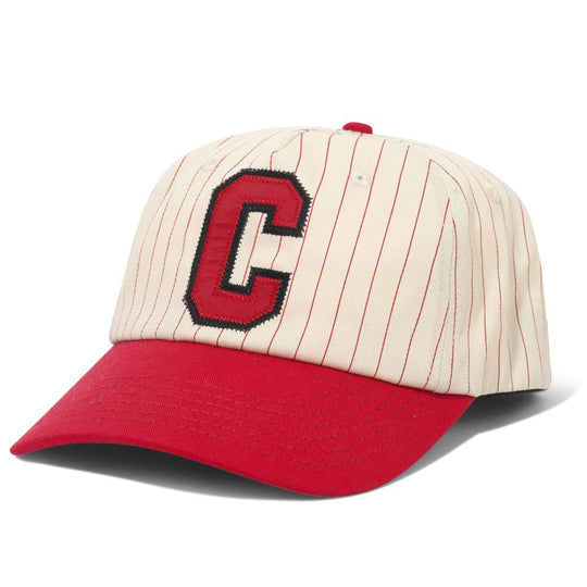 A baseball cap with an off-white pinstripe crown, a red curved brim, and a large red embroidered letter &