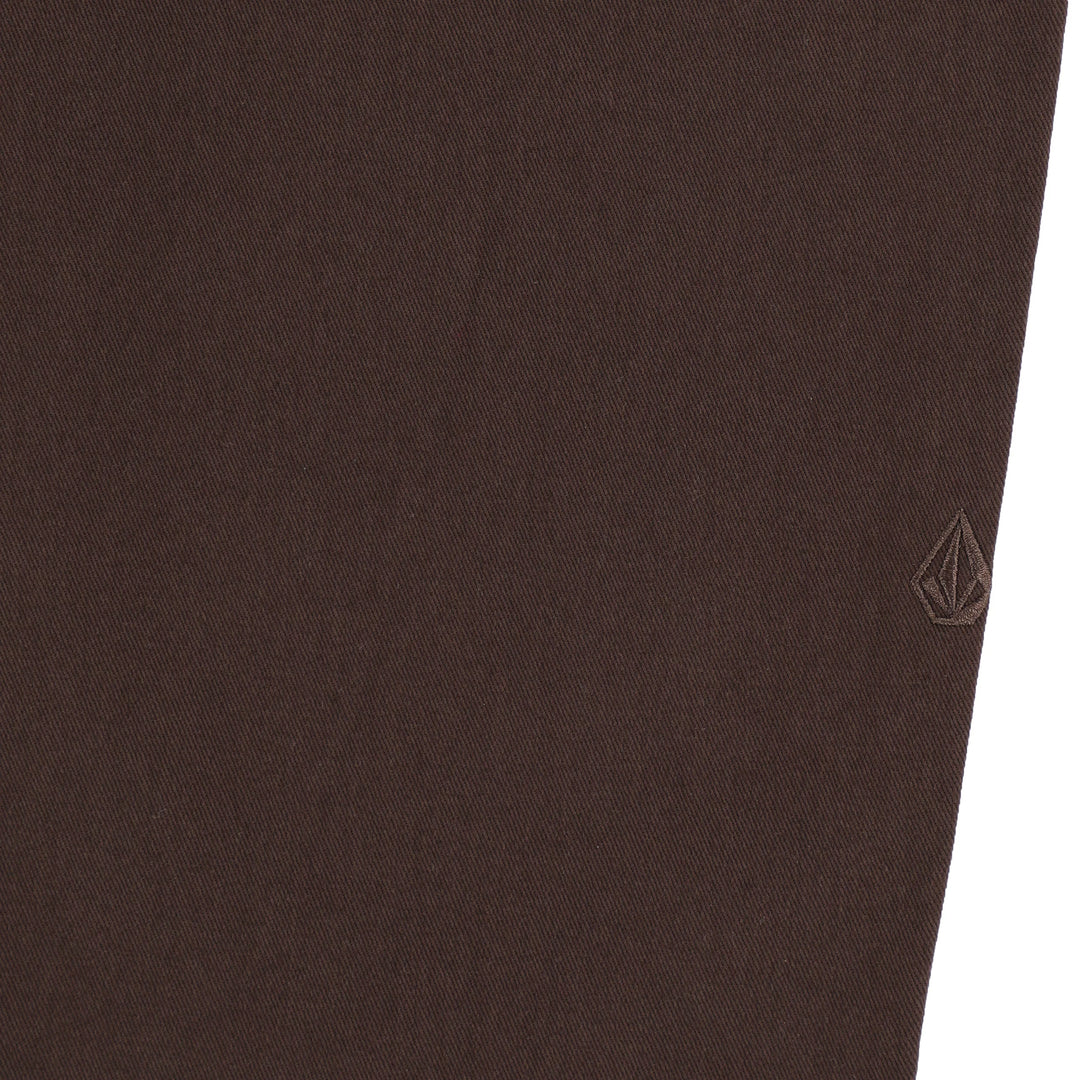 Close-up of brown pants with a brand logo on a white background
